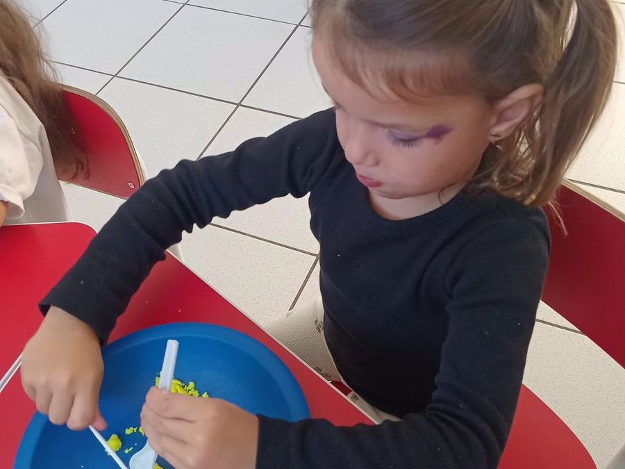 Criança brincando com massinha e talheres