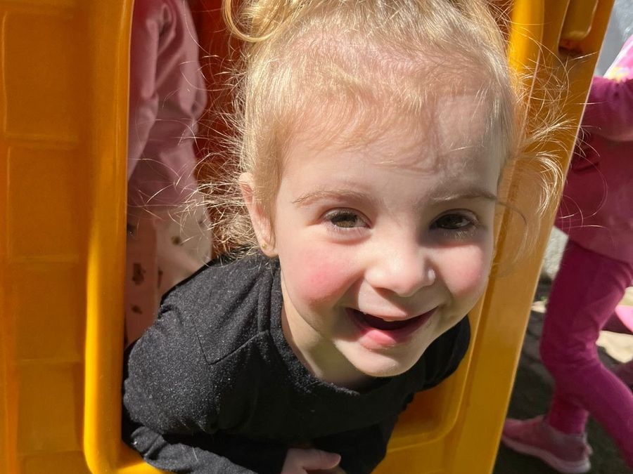 Menina sorrindo na casinha do parquinho